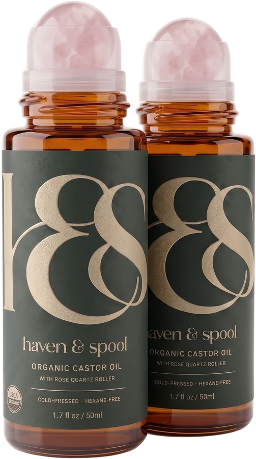 Two bottles of Haven & Spool organic castor oil with rose quartz rollers