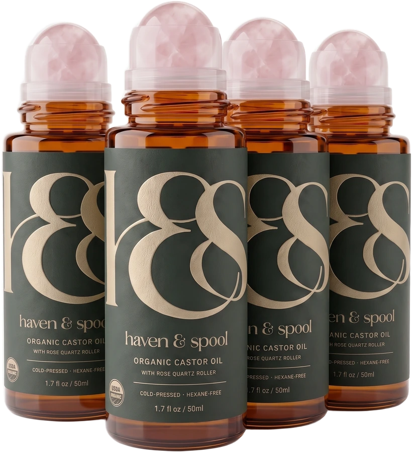 Four bottles of Haven & Spool organic castor oil with rose quartz rollers